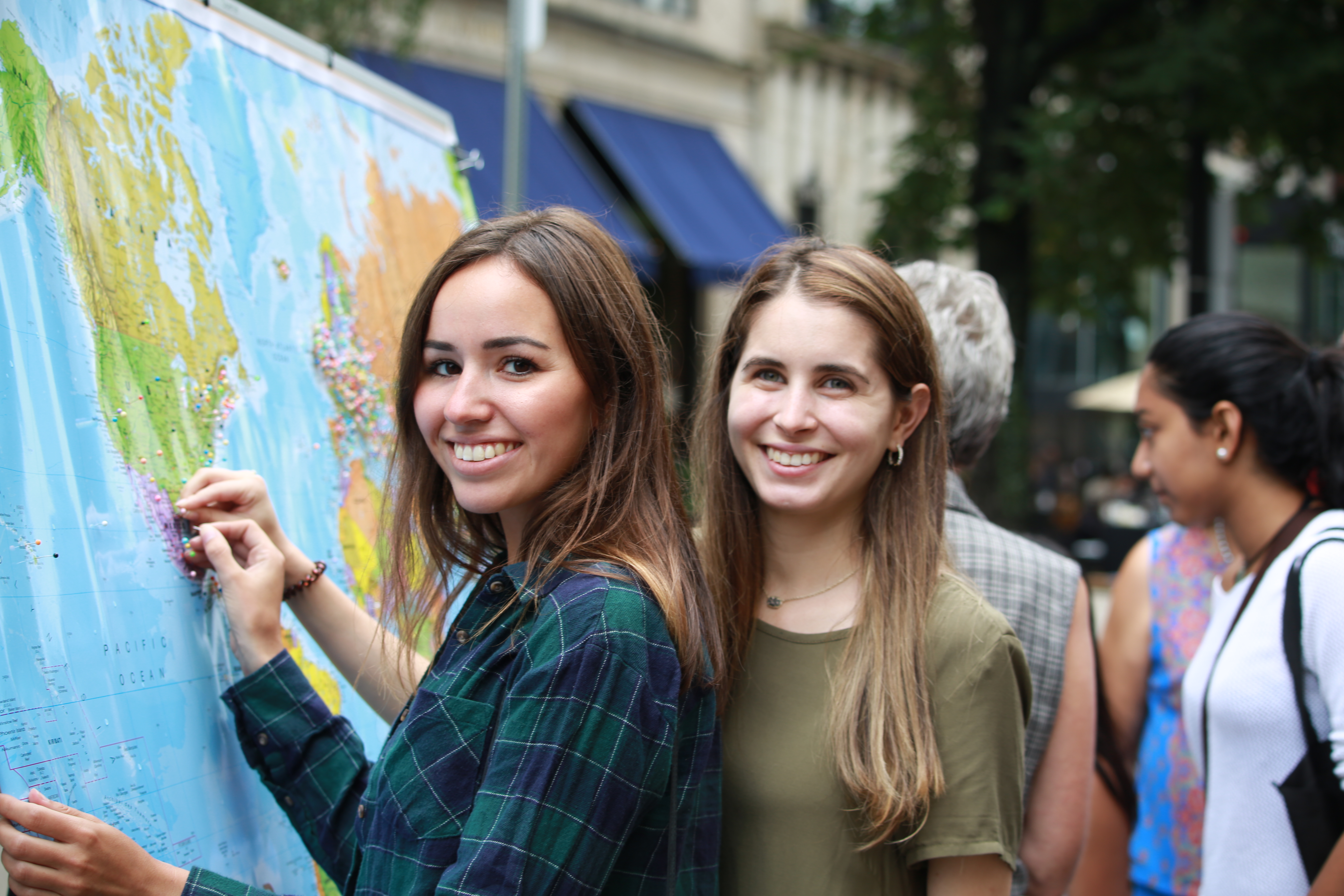 Smiling people pinning location to map