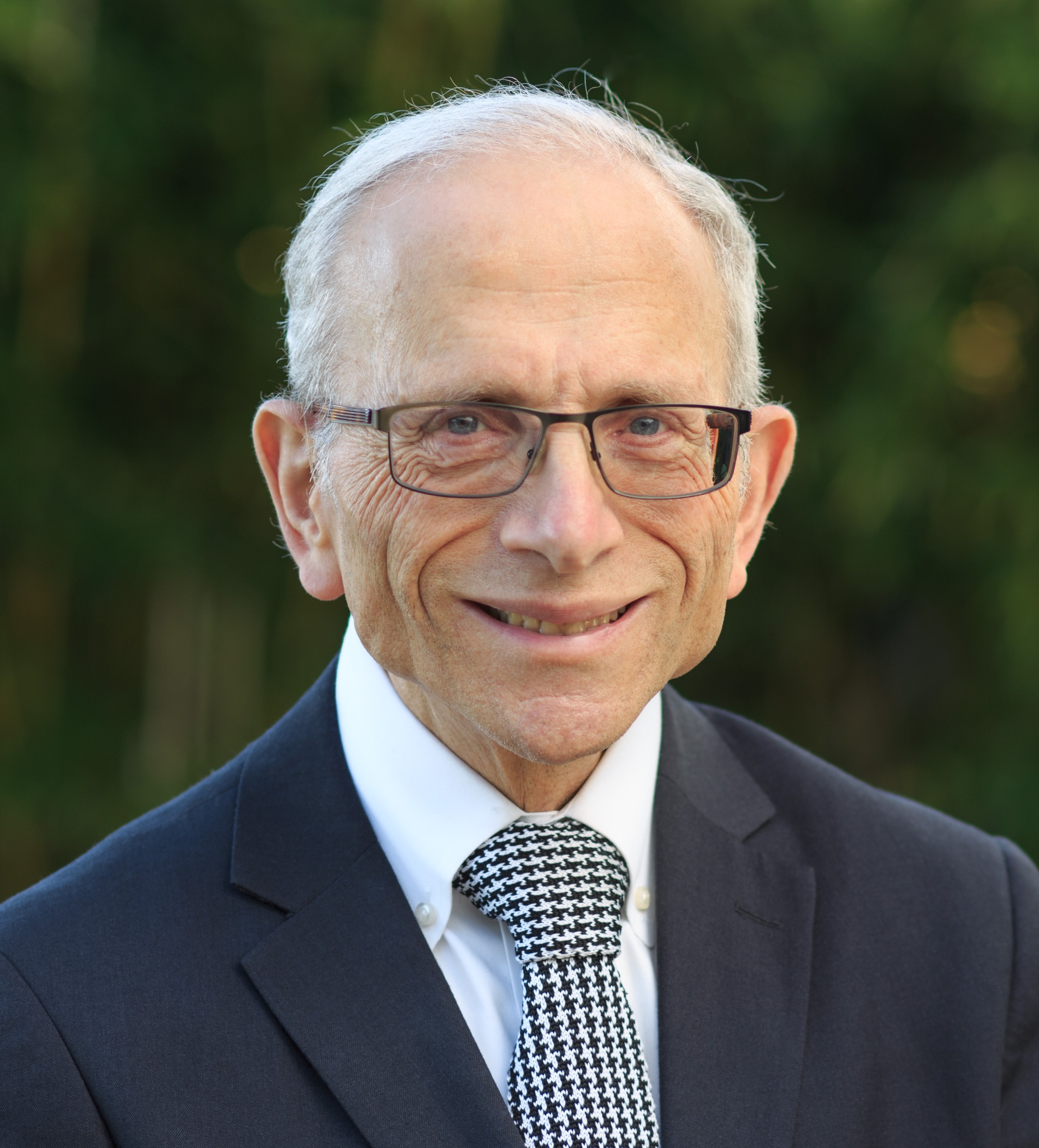 Headshot of Jonathan Sarna smiing, wearing suit and tie