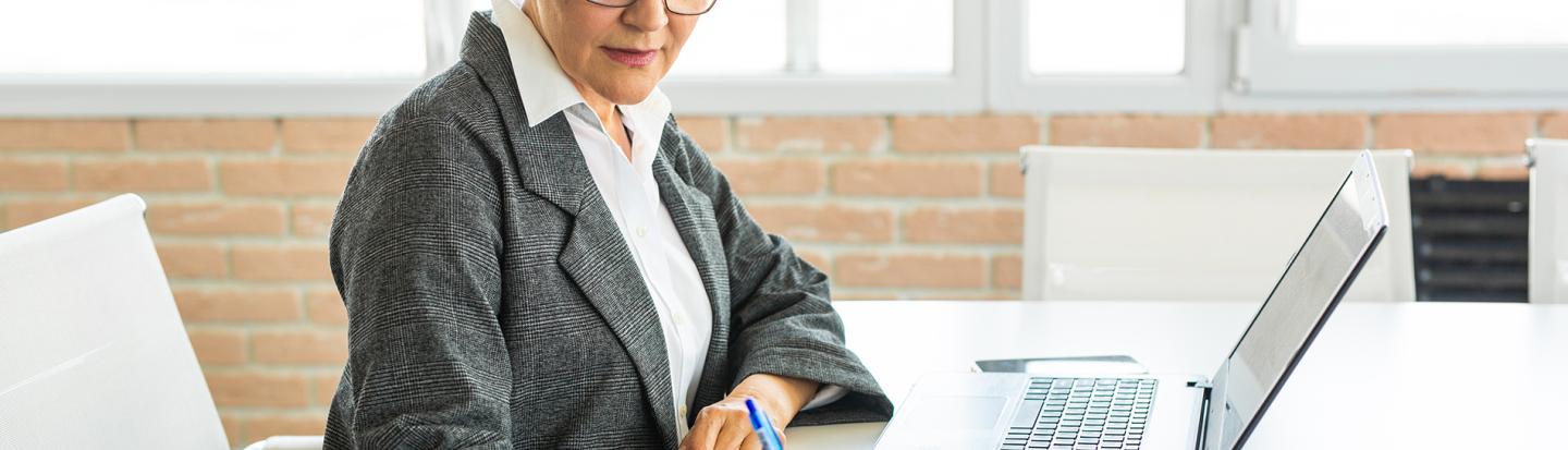 Woman Writing While on Laptop