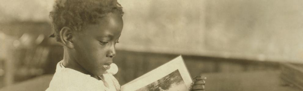 Young girl reading a book in a school room