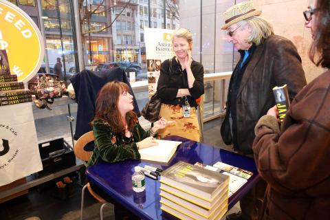 Holly George-Warren signing book for audience member while others watch