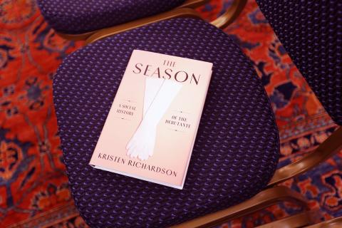 The Season by Kristen Richardson on a chair at event