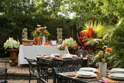 garden party setup with tables, plates, and flowers